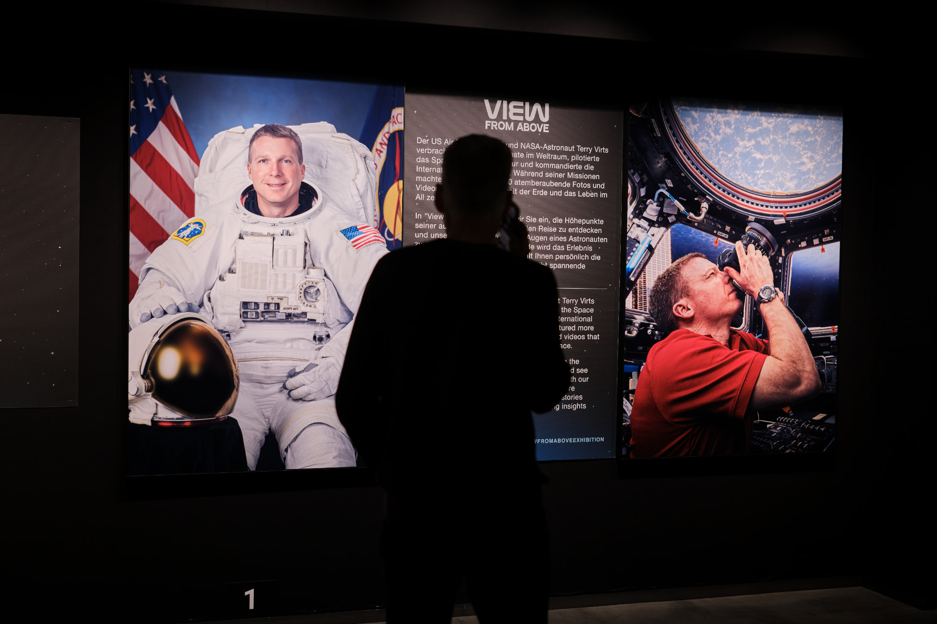 View From Above exhibition installed in a gallery, with backlit photographs of Earth from orbit